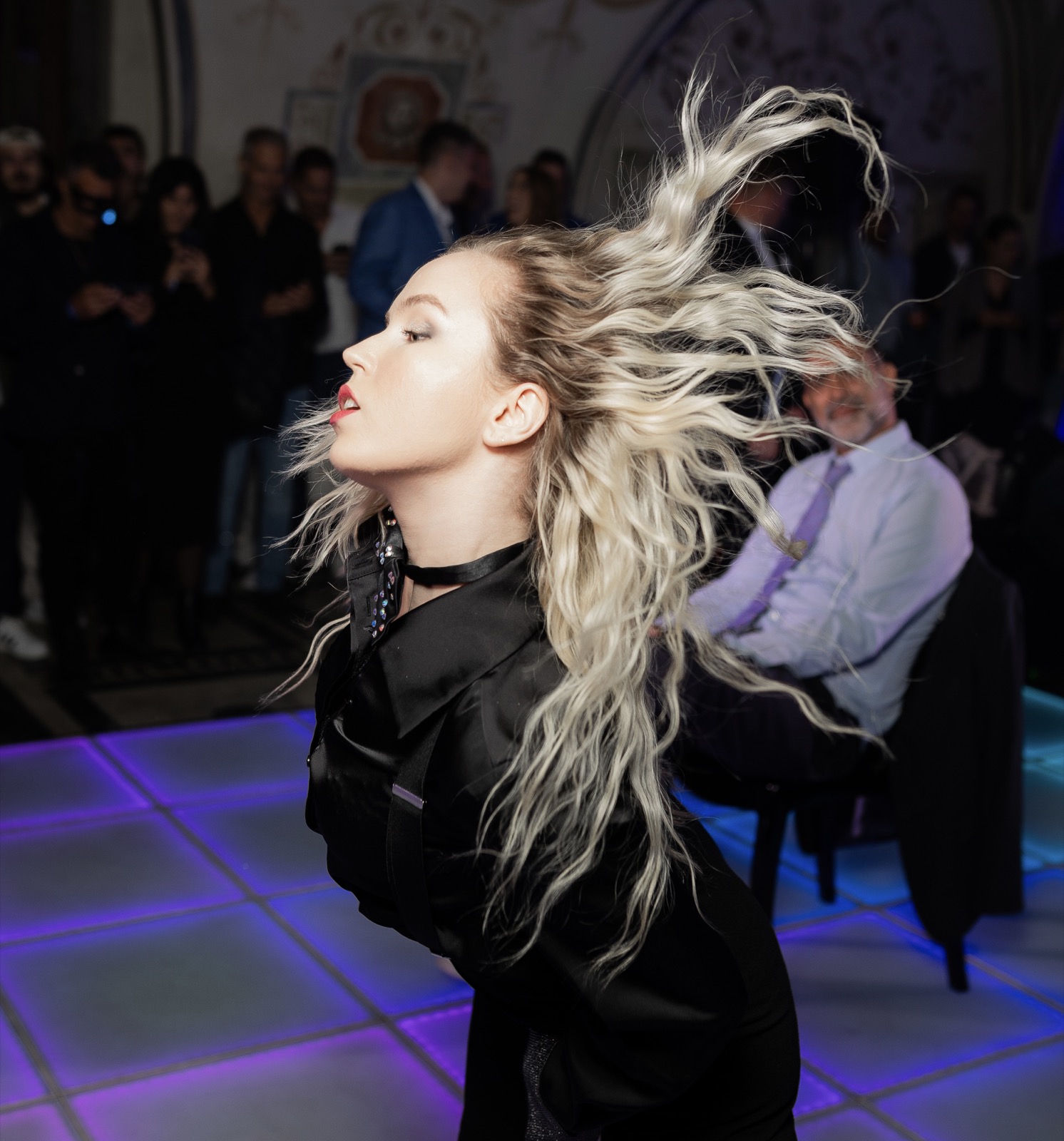 Dancer mid-motion with a hair flip on the dance floor